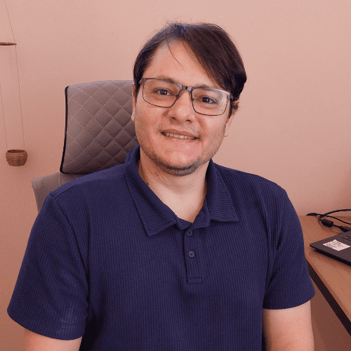 Psicólogo Fabiano sorrindo em seu consultório, representando o acolhimento e a experiência na psicoterapia para homens.